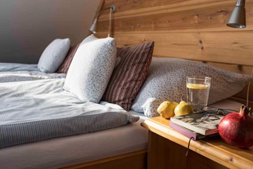 a bed with pomegranates and a book on a table at Penzion Slnecny Dom in Tatranská Lomnica