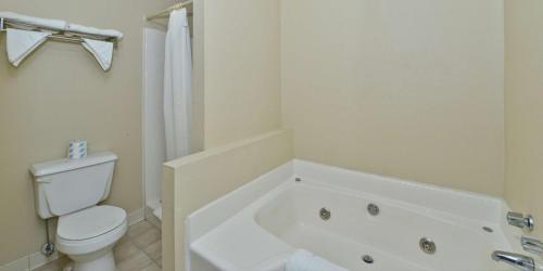 a white bathroom with a toilet and a bath tub at Americas Best Value Inn Hazlehurst in Hazlehurst