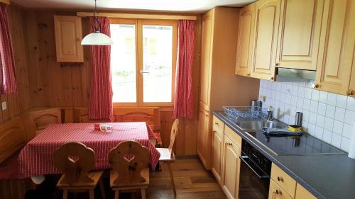 a kitchen with a table and a table and a window at Chalet Valaisia in Riederalp