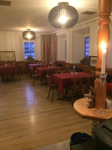 un restaurante con mesas y sillas con mesas rojas en Gasthof Sonne Häselgehr, en Häselgehr