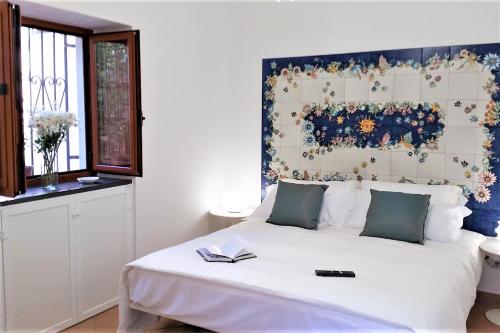 a bedroom with a large white bed with a floral headboard at La Corte dei Naviganti B&B - Amalfi Coast - Cetara in Cetara