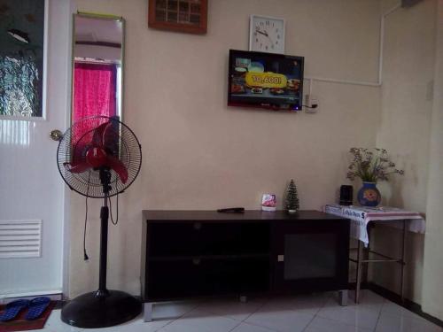 a living room with a fan and a tv at De Hagan Transient Baguio City in Baguio