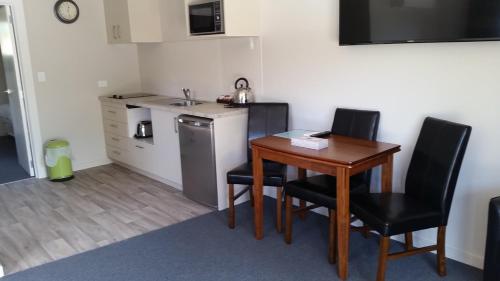 a small room with a table and chairs and a kitchen at Fairlie Holiday Park in Fairlie