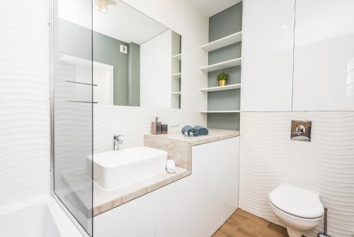 a bathroom with a sink and a toilet at Apartamenty Tespis - Francuska Atal Park in Katowice