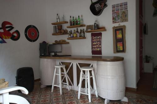 a bar in a room with two stools at La Puerta Roja Guest House in Santo Domingo