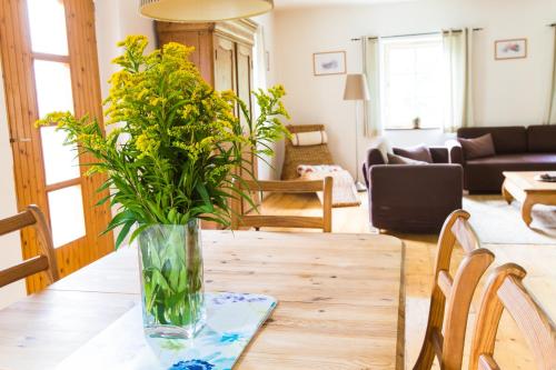 eine Vase mit Blumen auf einem Tisch im Wohnzimmer in der Unterkunft Lipno Family Cottage in Lipno nad Vltavou