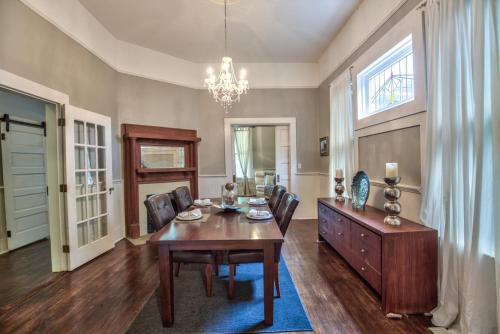 a dining room with a table and chairs and a chandelier at Classic/Modern Downtown Home in Valdosta