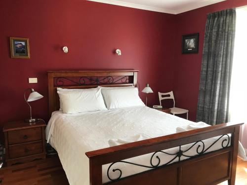 um quarto com uma cama grande e paredes vermelhas em Taras Richmond Farmstay em Richmond