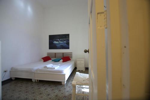 a bedroom with a bed with red pillows on it at La Puerta Roja Guest House in Santo Domingo