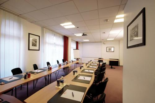 a conference room with long tables and chairs at Séjours & Affaires Courbevoie Grande Arche in Courbevoie