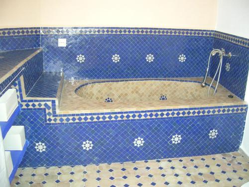 a blue tiled bathroom with a tub with a shower at Dar es Salam-Alta in Asilah