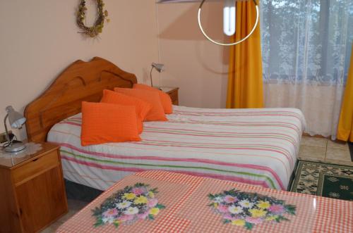 a bedroom with a bed with orange pillows at Los Gualles de la Candelaria Apart Hotel in Pucón