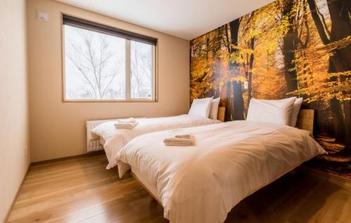 ニセコ町にある樺山 タウンハウスの壁に絵画が飾られたベッドルーム1室(ベッド2台付)