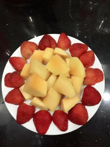 a plate of strawberries and melons on a table at Hue Homestay Riverside in Hue