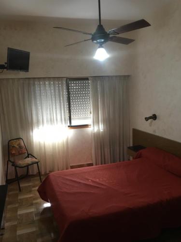 a bedroom with a bed and a ceiling fan at Hotel Condor in Buenos Aires