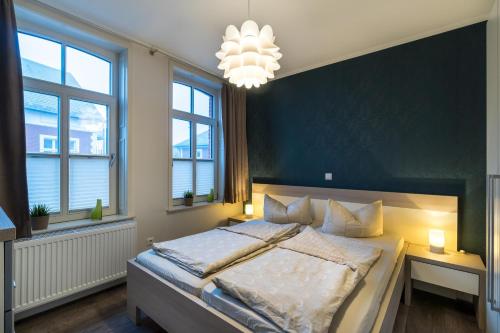 sypialnia z dużym łóżkiem i żyrandolem w obiekcie Altstadt Wohnung 4 "Bant" w mieście Borkum