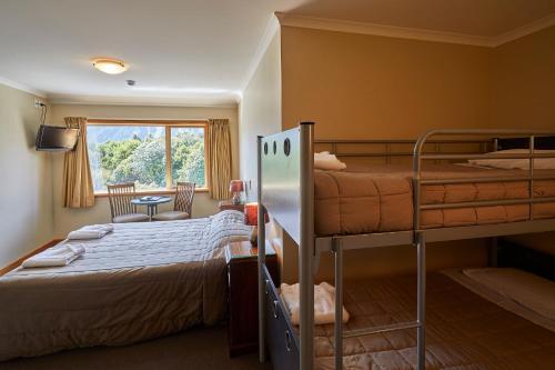 a bedroom with two bunk beds and a window at Aoraki Mount Cook Alpine Lodge in Mount Cook Village