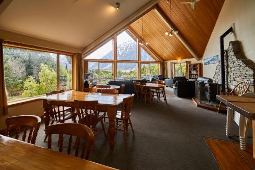 a dining room with tables and chairs and windows at Aoraki Mount Cook Alpine Lodge in Mount Cook Village