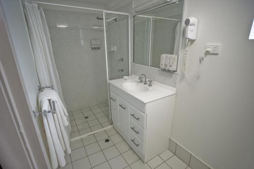 
a bathroom with a sink, toilet, and shower stall at Centrepoint Motor Inn in Rockhampton
