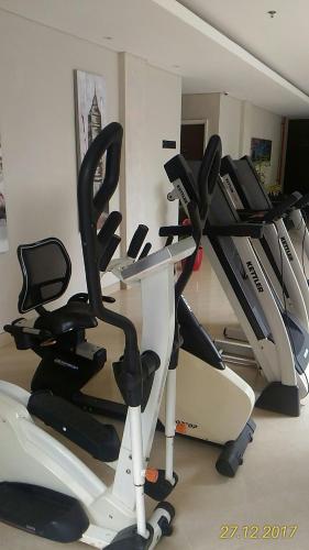 a gym with several cardio machines in a room at Ohana Hotel Kuta in Kuta