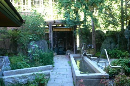 a garden with a pool of water in a yard at Yuttarino-Sato Inaka in Achi
