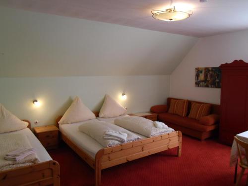 a bedroom with a bed and a couch in it at Hotel Gasthof zum Neubau in Kißlegg