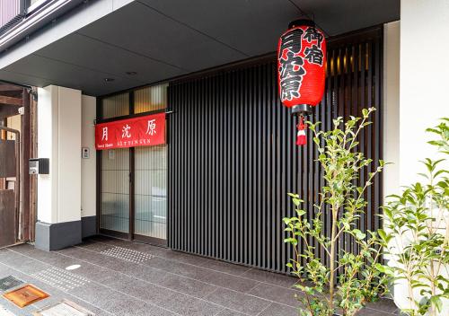 un bâtiment avec un panneau rouge sur son côté dans l'établissement Guest House Goettingen, à Kyoto