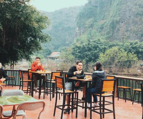 Un grupo de personas sentadas en mesas en un patio. en Tam Coc Bungalow, en Ninh Binh
