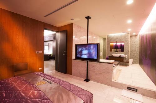 a bedroom with a bed and a flat screen tv at 富士都商務汽車會館 台南市旅館308號 in Tainan