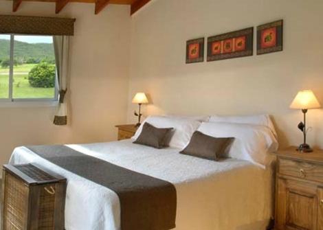 a bedroom with a large white bed with two pillows at El Portillo in Villa General Belgrano
