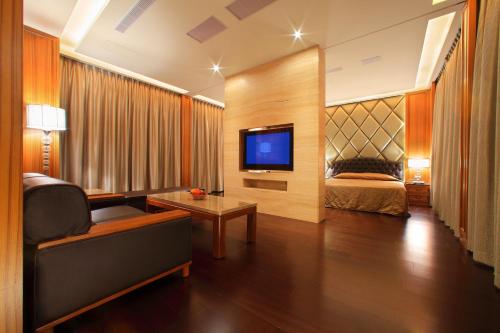 a hotel room with a television and a bed at Spring Hotel in Taichung