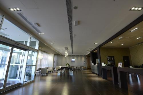 an empty lobby with tables and chairs in a building at Best Western Premier CHC Airport in Genova