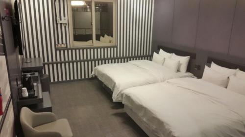 Ένα ή περισσότερα κρεβάτια σε δωμάτιο στο Jinju Kai Hotel