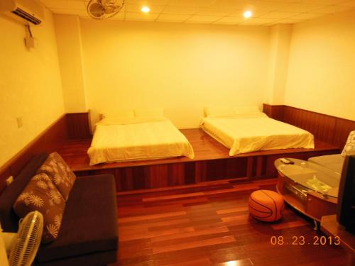 花蓮市的住宿－信義之家，一间设有两张床和一张沙发的房间