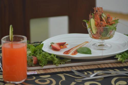 uma mesa com um prato de comida e uma bebida em Hotel Golden Ray em Dambulla