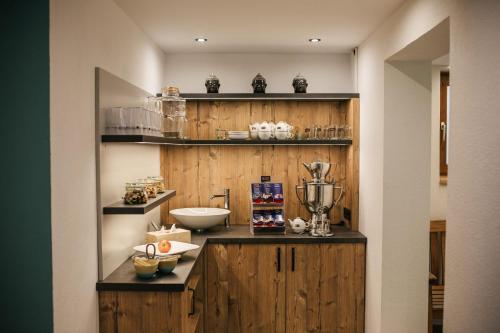 a kitchen with wooden cabinets and a counter with a blender at Hotel Die Arlbergerin - Design & Tiroler Gemütlichkeit in Sankt Anton am Arlberg
