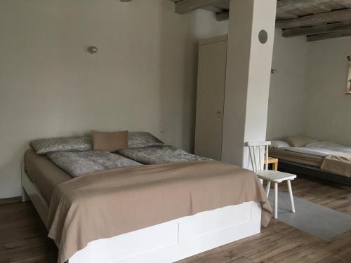 a bedroom with a large bed and a chair at Am Ziegenhof in Parndorf
