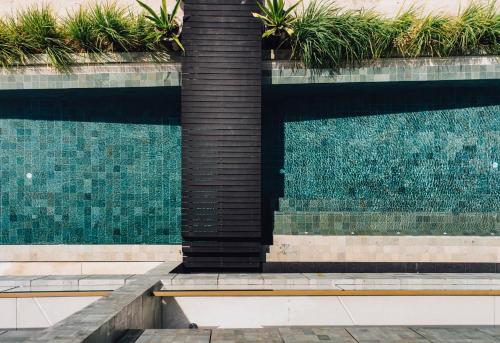 a fountain in front of a swimming pool at The Beach Samui in Taling Ngam Beach