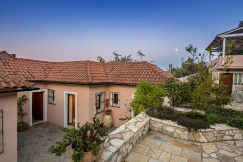 a house with a stone wall in front of it at Harry's Studios 1 in Gaios