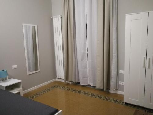 パレルモにあるRe Federico Apartmentの鏡とカーテン付きの窓が備わる客室です。