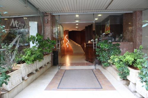 a store with a hallway with stairs and plants at Mozart Hotel in Beirut