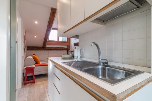 a kitchen with a stainless steel sink and white cabinets at Rialto Mini in Venice