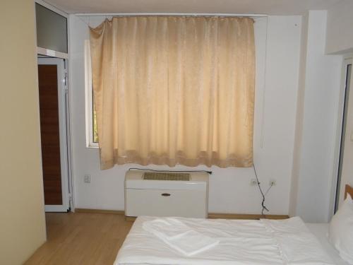 a bedroom with a white bed and a window at Hotel Pilevski in Blagoevgrad