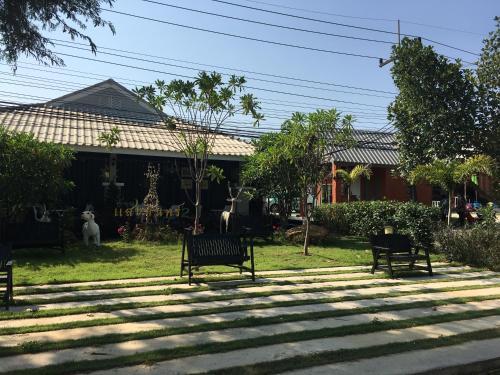 um grupo de bancos sentados em frente a uma casa em Baan Sang Chan 2 em Ban Krang