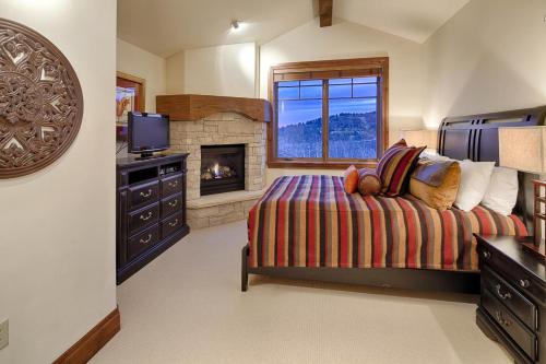 1 dormitorio con 1 cama con chimenea y TV en Silver Strike #702 - 1 Bed, en Park City