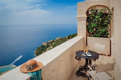 a balcony with a table and a view of the ocean at Monastero Santa Rosa Hotel & Spa in Conca dei Marini