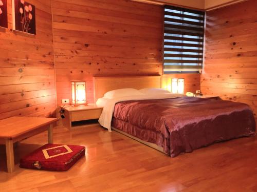 台北的住宿－東姿商務旅館，一间卧室设有一张床和木墙