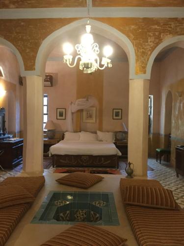 a large bedroom with a bed and a chandelier at Al Moudira Hotel in Luxor
