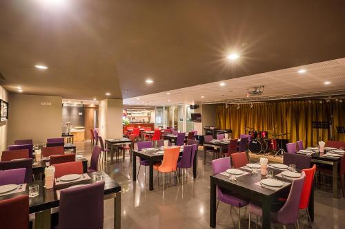 a dining room with tables and purple chairs at Beyond Suite in Bangkok