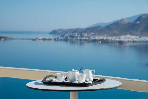 a tray of coffee cups and saucers on a table overlooking the water at Naxos Rock Villas in Stelida